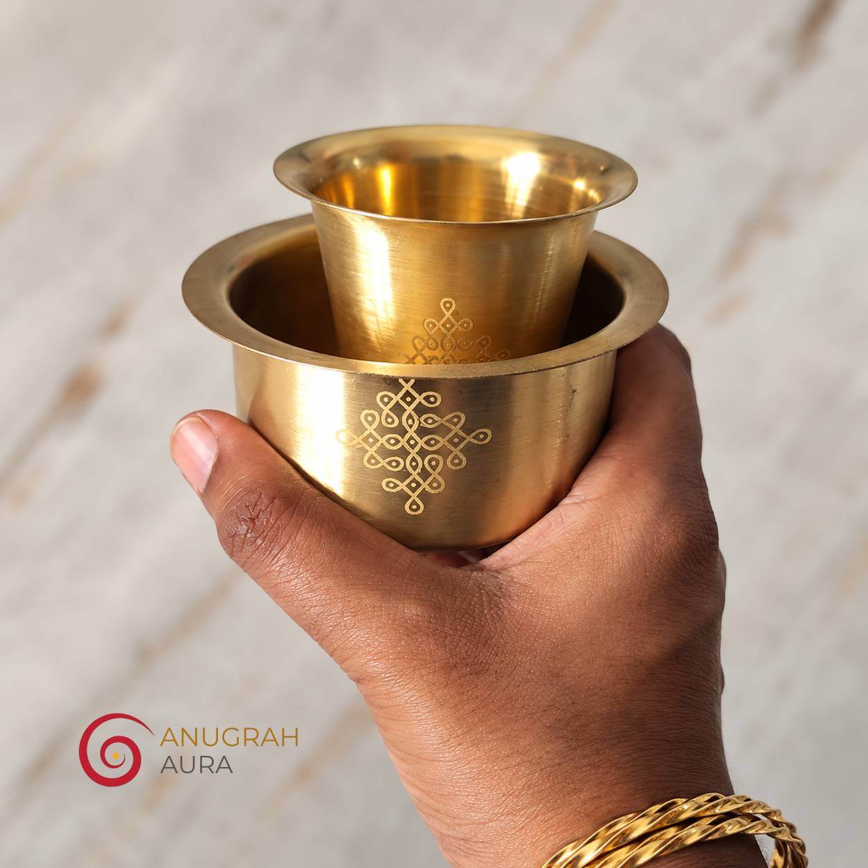 Traditional brass dabara set with engraved tumbler and davara displayed in hand